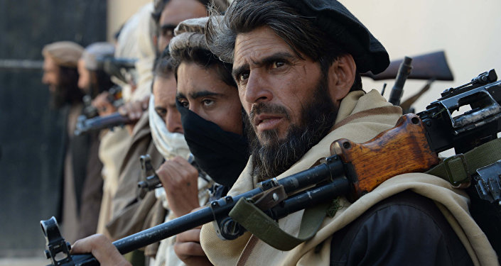 Afghan alleged former Taliban fighters carry their weapons before handing them over as part of a government peace and reconciliation process at a ceremony in Jalalabad on February 24, 2016